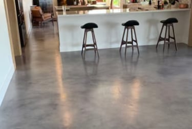 Modern open-plan kitchen with polished grey concrete flooring.