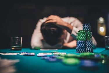 a man is sitting at a table with poker chips and playing cards