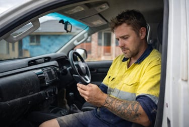 Australian tradie checking jobs from work ute