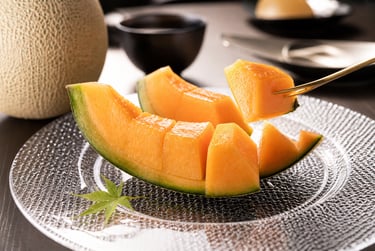 Slices of fresh ripe cantaloupe melon served on a glass plate for a healthy fruit dessert.