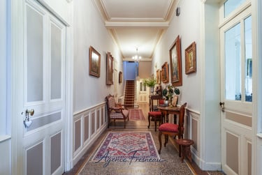 Élégant hall d’entrée de style classique avec tapis persans, œuvres d’art encadrées aux murs.