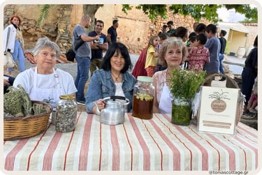 Three women at an outdoor stall at the Cretan Cuisine Festival.