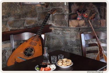Rustic table set with a lyra, Cretan lute, glasses, and plates of local food inside a stone
