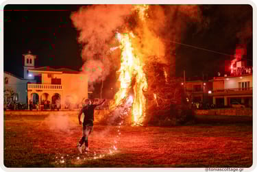 Cretan Easter bonfire: man igniting a massive pyre with a torch amid flames and smoke