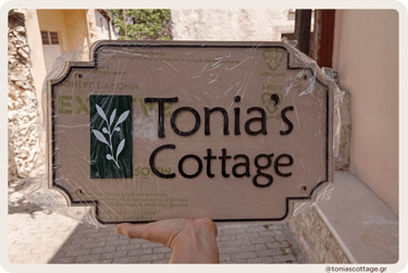 Tonia's Cottage holiday rental logo in Crete, Greece, held in hands before placing on the wall