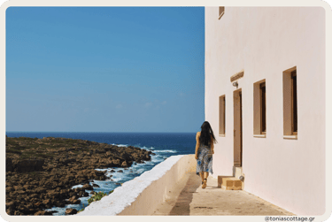 Woman walking by a white church near the sea on the Cretan shore