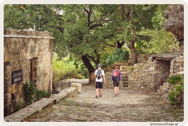 People walking a shaded path in a Cretan village.
