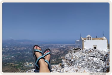 Summer on Mount Juktas: feet in sandals resting above a chapel and vast Cretan valley view