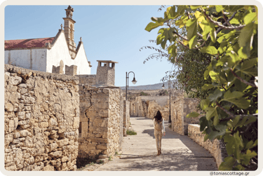 Woman walking in a quiet village in Crete on a calm, sunny day