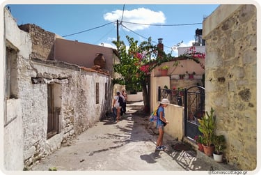 Family strolling past traditional stone homes in Alagni Village in Crete.