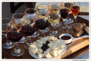 Wine glasses with red and white wines, served with cheese, olives, rusks, and dip on a tray