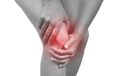 A person holding their knee with a red glow indicating chronic joint pain and inflammation.