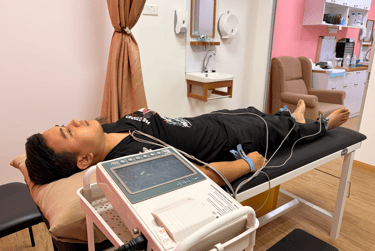A patient undergoing an EKG test with electrodes attached to his limbs in a medical clinic.