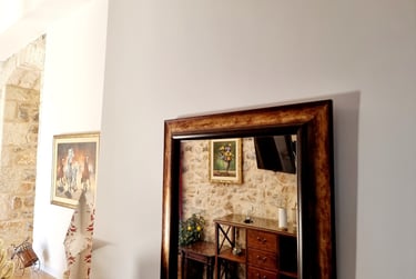 a mirror reflecting a stone wall in a room