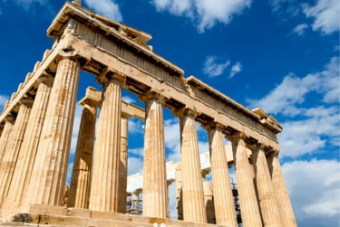 Low angle view of the Parthenon temple at the Acropolis of Athens with marble columns and blue sky.