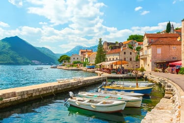 Fishing boats moored in a stone harbor in the historic coastal town of Perast, Montenegro.