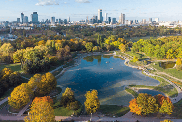 Aerial view of Pole Mokotowskie park in Warsaw with autumn trees and city skyline.