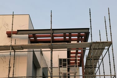 Modern villa entrance canopy with structural steel frame and sleek ACP facade cladding.