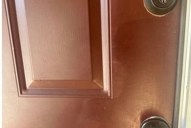 Red home door with deadbolt and knob representing residential locksmith services in Candler, NC for rekeying & smart locks