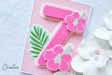 Pink Cricut birthday card with number 7 and pink flowers and leaf.