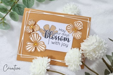 Orange handmade spring card with die cut flowers and spring-themed sentiment