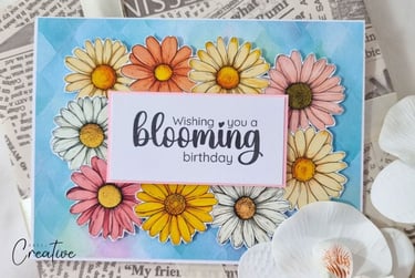 Handmade greeting card with lot of yellow, white and blush flowers on the blue background.