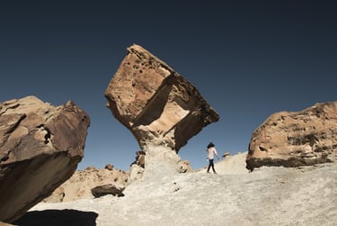 Rocky background with clear sky and a person walking towards unknown direction.
