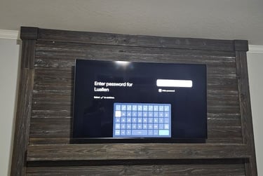 Smart TV mounted on a rustic wood fireplace mantel displaying a Wi-Fi password login screen.