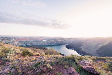 Aerial view of Flaming Gorge Reservoir at sunrise with scenic mountain ridges and canyon landscape.