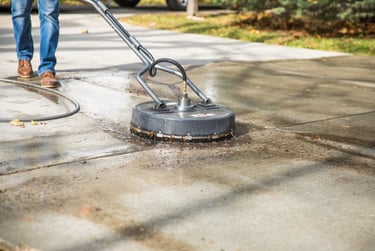 man surface cleaning a drive way