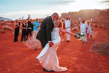 a bride and groom kissing in the desert