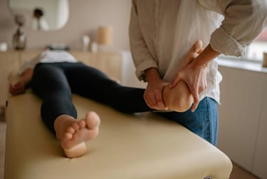Une femme bénéficie d'une séance de réflexologie plantaire dans une pièce apaisante, entourée d'une ambiance calme.