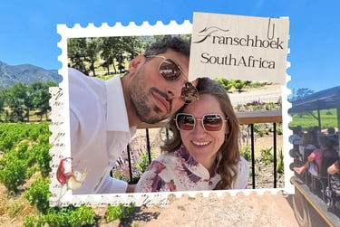 A happy couple wearing sunglasses at a Franschhoek South Africa vineyard on a sunny day.
