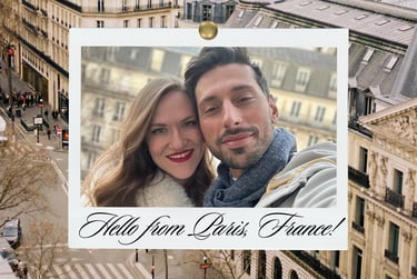 A smiling couple takes a selfie in a Polaroid-style frame with a Paris, France cityscape backdrop.