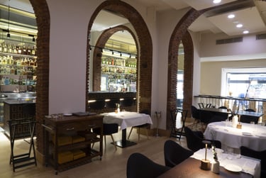Sala principale del Quadri Bistrot a Milano con archi in mattoni e cocktail bar sullo sfondo