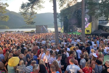 A crowd of people standing with a lake in the background-Truengen Festival
