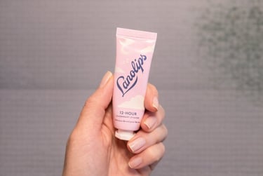 Hand holding Lanolips 12-hour overnight lip mask for deep hydration and smooth lips