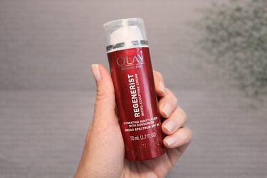 Hand holding Olay Regenerist Micro-Sculpting Cream with SPF for hydrating anti-aging skincare