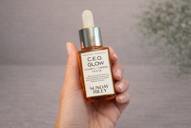 Hand holding Sunday Riley C.E.O. Glow vitamin C face oil with turmeric for radiant skin