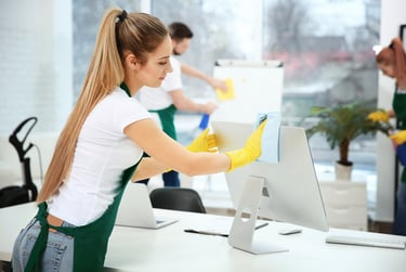 a woman cleaning a computer screen in a room