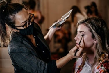 Professional makeup artist Cha Sloan applying eye shadow to a bride for a wedding ceremony.