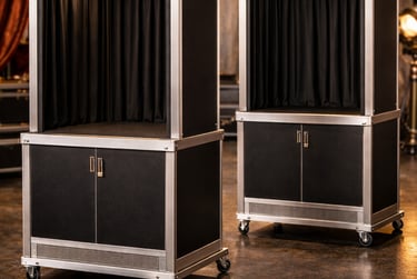 Two portable luxury photo booths with black curtains and aluminum frames on wheels for event entertainment.