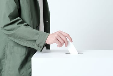選挙の投票箱に投票用紙を入れる人の手元を写した写真。堺市南区の投票所変更ニュース記事用のイメージ画像。
