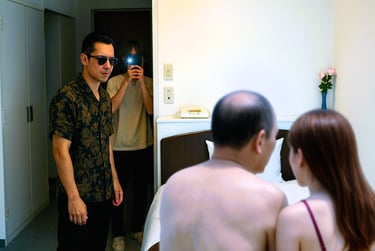 ホテルの部屋で男女が座る前に男と撮影する人物が現れる、美人局の手口のイメージ画像｜堺市のニュースならサカイタイムズ