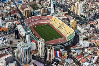 Vista interna do Estádio Hernando Siles em La Paz, mostrando as arquibancadas coloridas e a pista de atletismo.