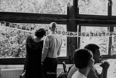 Wedding guests looking at polaroids during reception.