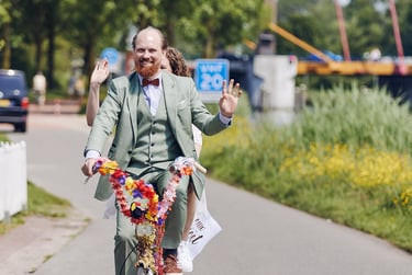Braut und Bräutigam kommen mit dem Fahrrad am Hochzeitsort an.