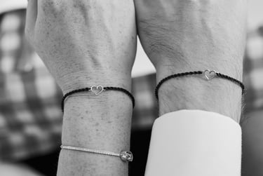 Nahaufnahme von Armbändern mit einem Herz, die von Braut und Bräutigam getragen werden.