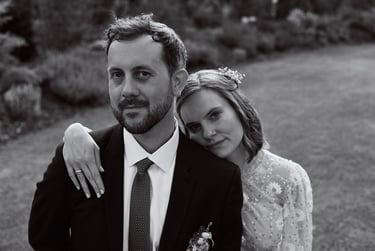 Bride standing behind groom leaning on his shoulder.