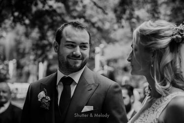 Der Bräutigam lächelt die Braut an.